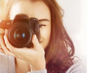 Pretty woman is a proffessional photographer with dslr camera