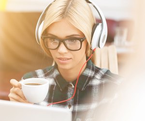 Cheerful young woman is resting with technology