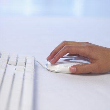 Hand with computer mouse and keyboard