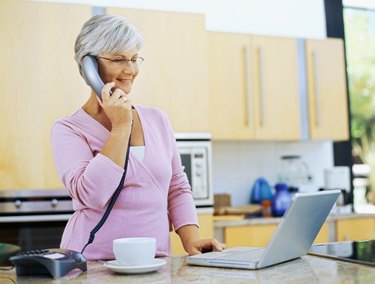 mature woman talking on a landline phone