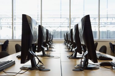 two rows of computers, flat screen monitors