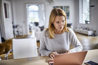 Woman using laptop on table at home