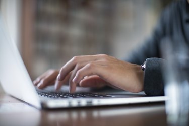 Close up hands typing on a laptop