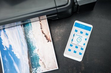 Smartphone connected to the wireless printer is laying on the desk