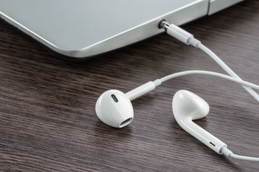 earphone with laptop on the wood desk