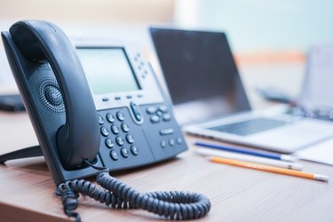 close up soft focus on telephone devices at office desk for customer service support concept