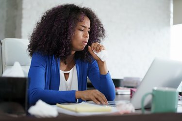 African American Woman Working At Home Coughing And Sneezing