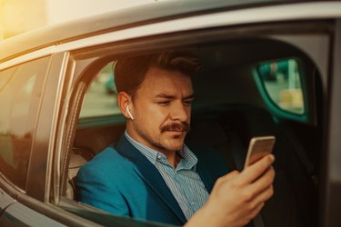 Businessman in the car texting