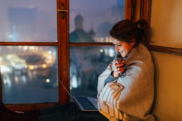 Smiling woman at home watching movie on the laptop