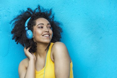 Woman in yellow vest and blue headphones