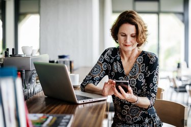 Businesswoman Using Smartphone While Sitting At Restaurant Bar