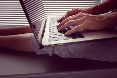 girl holds a MacBook Pro Retina on her lap and something prints