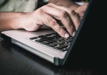 Man typing on an Apple MacBook