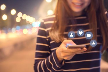 Woman hands using mobile smartphone on the street with icon social media and social network.