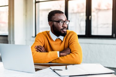 smiling african american businessman with crossed arms in office