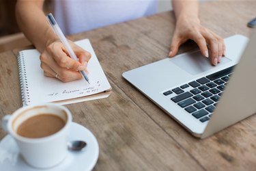 Cropped View of Woman Working on Laptop in Cafe