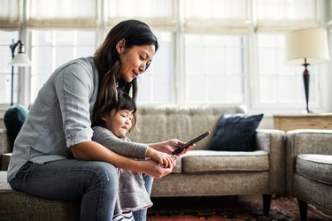 Mother using smartphone with children present