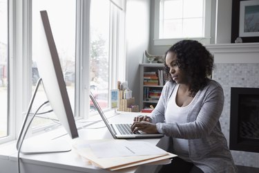 Woman working at laptop in home office