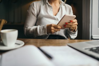 Attractive woman using cell phone to schedule a meeting