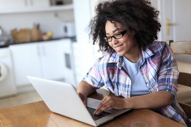 Woman with eyeglasses using laptop at home