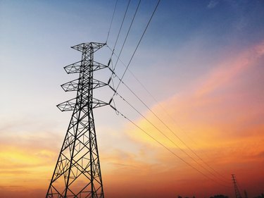 Low Angle View Of Silhouette Electricity Pylon Against Dramatic Sky During Sunset