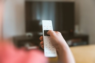 Cropped Hand Using Television Set Remote Control At Home