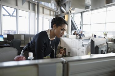 Businesswoman using computer in office cubicle