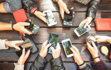 People group having addicted fun together using smartphones - Detail of hands sharing content on social network with mobile smart phones - Technology concept with millennials online with cellphones