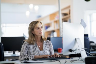 Confident businesswoman using computer in office