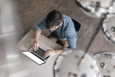 Young man working on laptop, top view