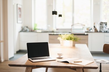 Laptop and notebook on table at home