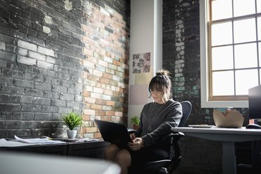 Creative businesswoman using laptop in office
