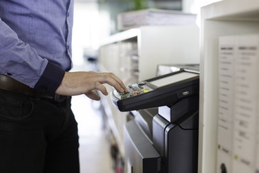 Businessman pressing the start button to print.