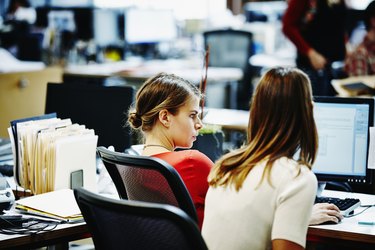 Two businesswomen sitting working on computer