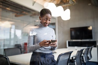 Business woman using cellphone in office