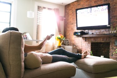 woman relaxing online on sofa reading some papers