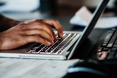 Close Up Of Man Typing On Laptop