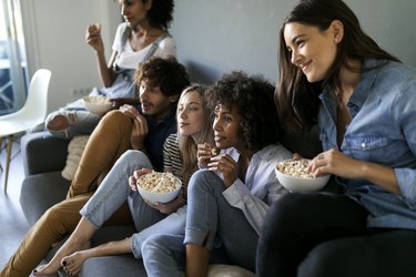 Friends sitting on couch watching tv