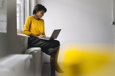 Woman sitting at the window using laptop