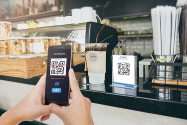 Qr code payment, E wallet , cashless technology concept. Man scanning  tag in Coffee shop accepted generate digital pay without money.