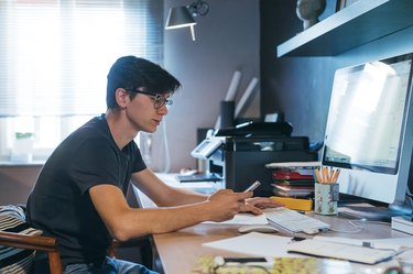 Man using cellphone at desk