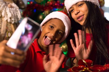 Siblings taking selfie photos during Christmas time at home