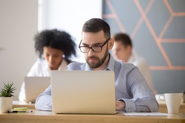 Serious businessman focused on computer online work in coworking office