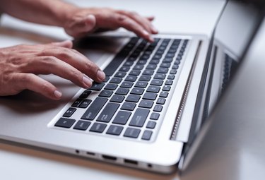 Close-up of man hands typing on the laptop