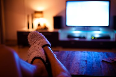Man putting feet up and watching television