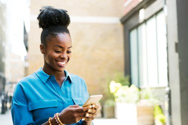 Smiling woman using smartphone