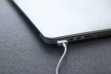 charge battery laptop and smartphone on fabric background