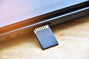 Close-Up Of Memory Card By Laptop On Table