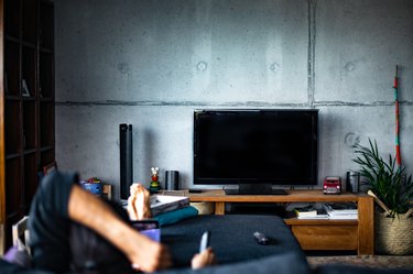 Rear view of a man watching television in a living room