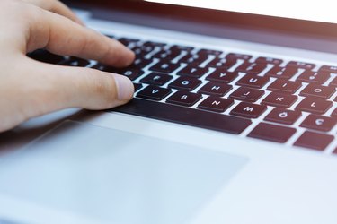 Hands typing on laptop computer